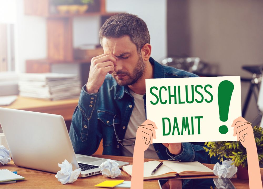 Mann sitzt verzweifelt am Schreibtisch