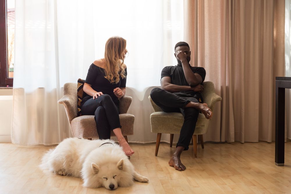 Mann und Frau streiten sich, Hund liegt davor